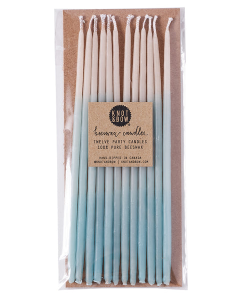 Package of 12 tall hand-dipped aqua color beeswax birthday candles with ombré effect