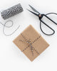 box wrapped in kraft paper and tied in a bow with black and white twine