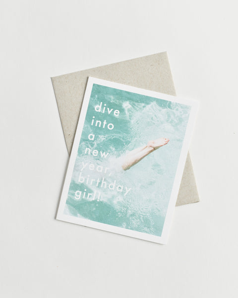 Photo greeting card of legs diving into clear blue water and words “dive into a new year, birthday girl!”