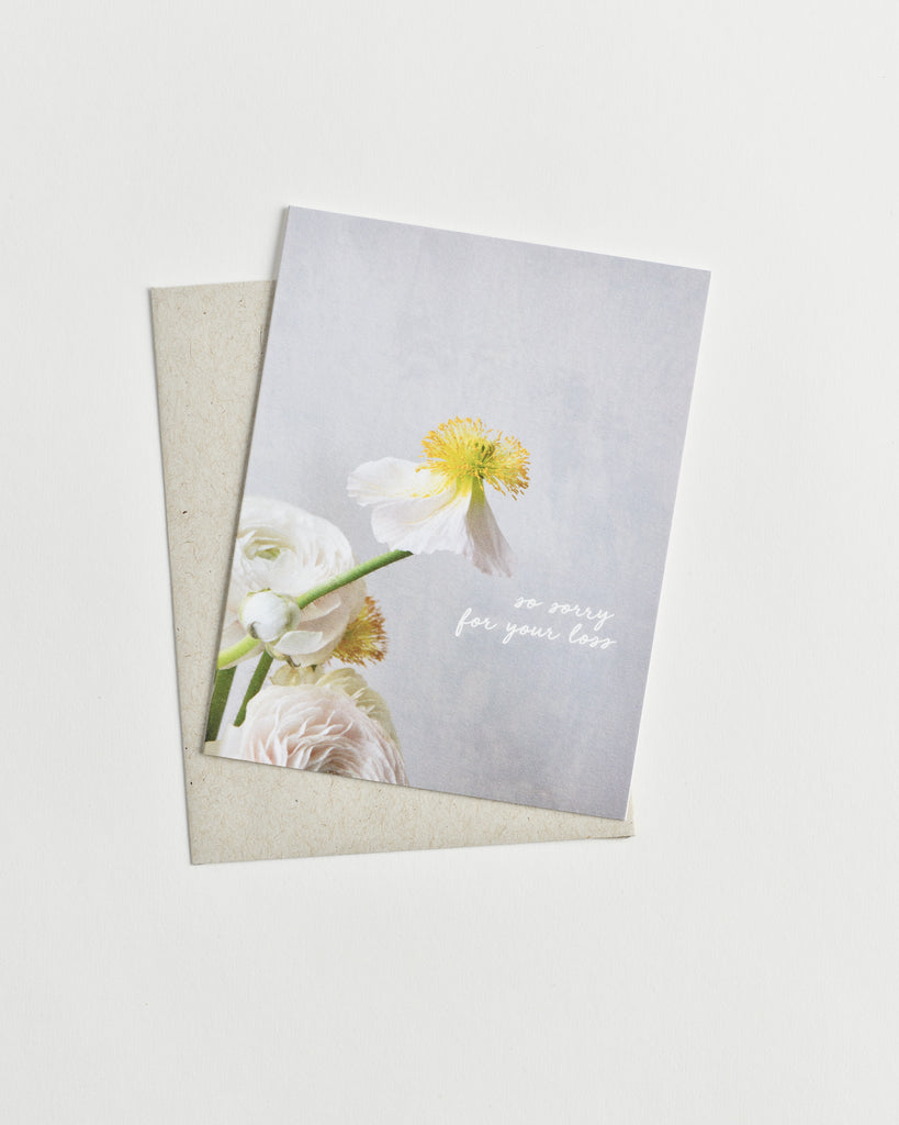 Photo greeting card of a white and yellow flower and words “so sorry for your loss” in cursive.