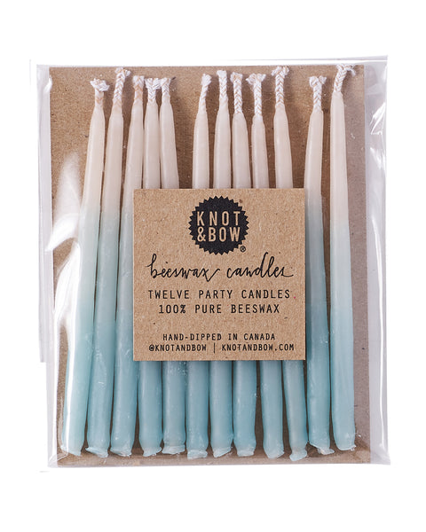 Package of 12 hand-dipped aqua color beeswax birthday candles with ombré effect