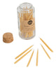 Hand-dipped beeswax candles in a natural pale yellow color, packaged in a glass jar with a cork top.