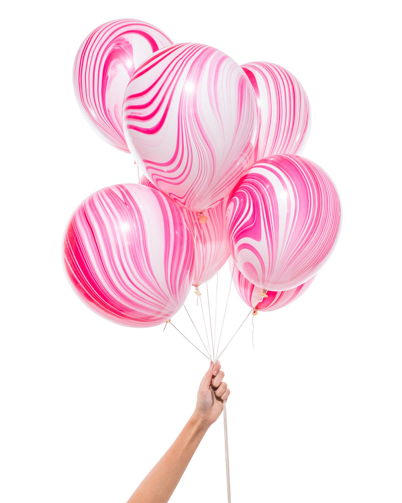Bunch of pink and white party balloons with a marble effect.