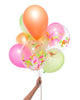 Bunch of party balloons in a mix of neon colors and clear balloons filled with neon confetti